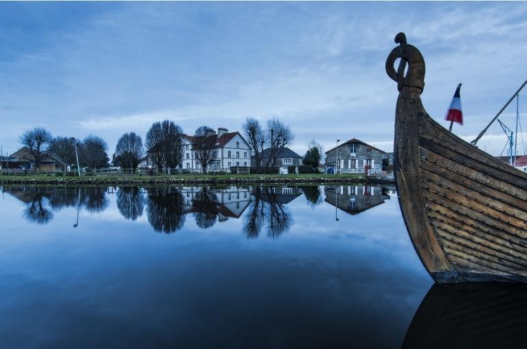 wooden ship in Carentan quay with reflections in water