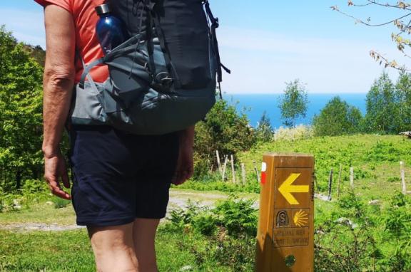 Pilgrim in front of Camino sign