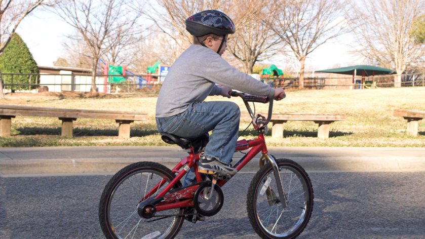 Boy with helmet riding a junior red bike
