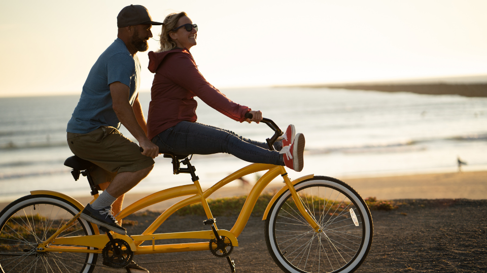 Happy couple on a yellow tandem bike