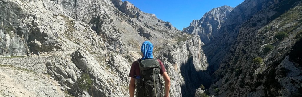 Hiker staring at the Picos de Europa while walking the Anillo Vindio