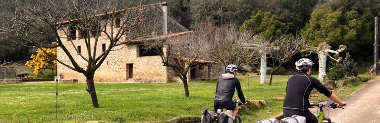 Cyclists passing a typical masia in Girona